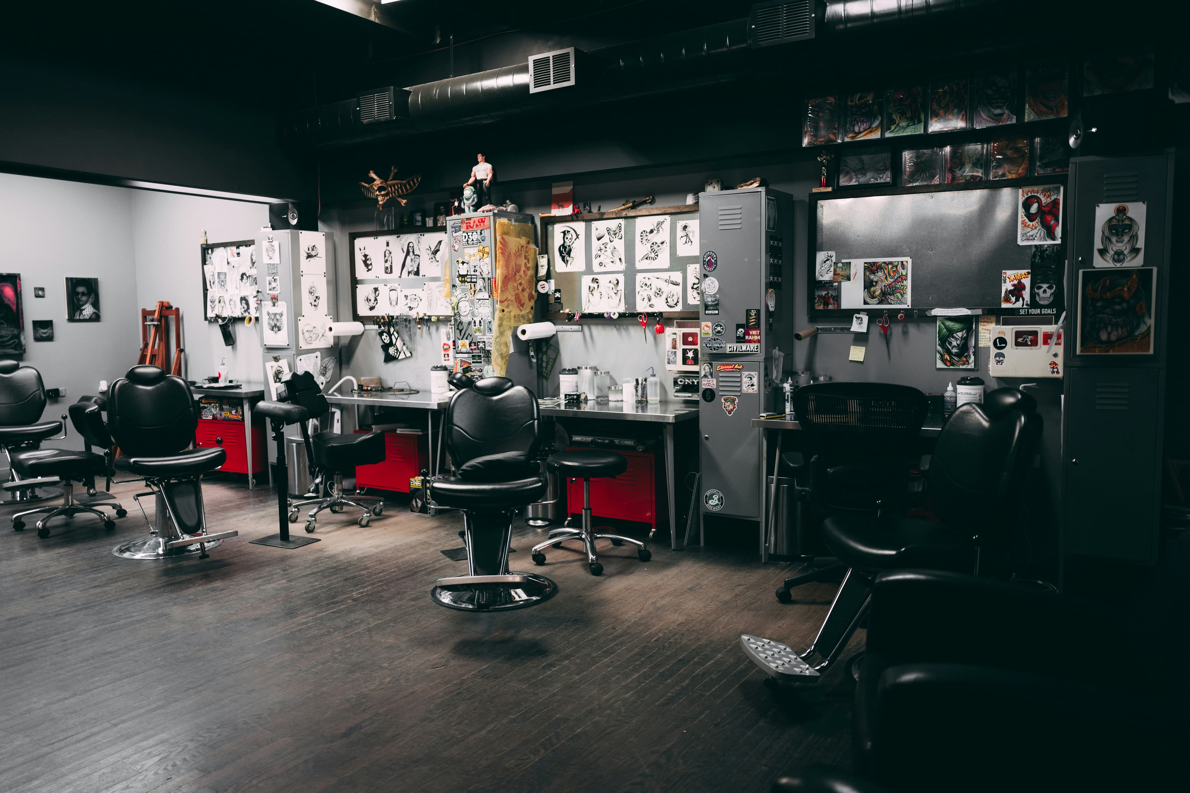 Interior of Sharp Barber Bangkok with black leather barber chairs, steel workstations and artwork on dark walls